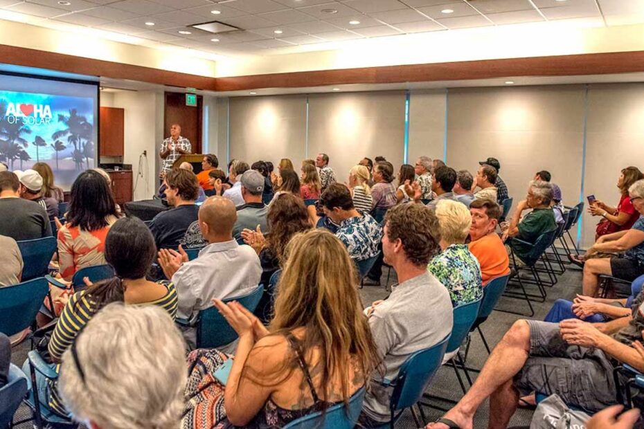 aloha of solar conference put on by rising sun solar. Features people siting in a conference style setting with a projection display