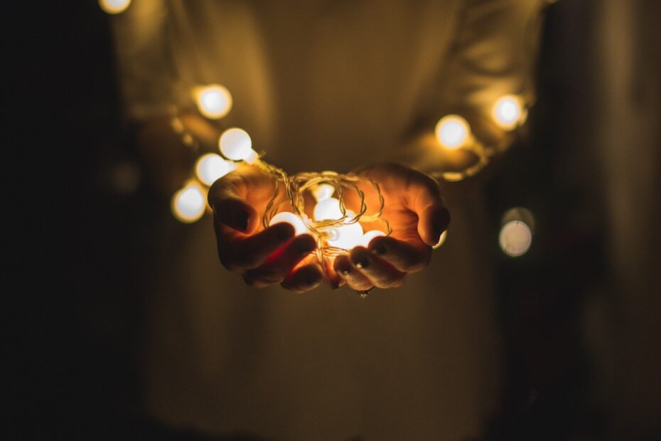 person holding christmas lights in the palm of their hand